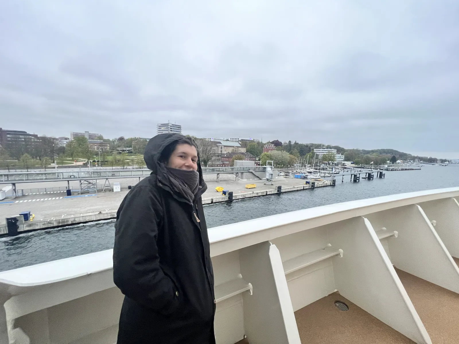 Jule an der Reling mit Blick über den Kieler Hafen.