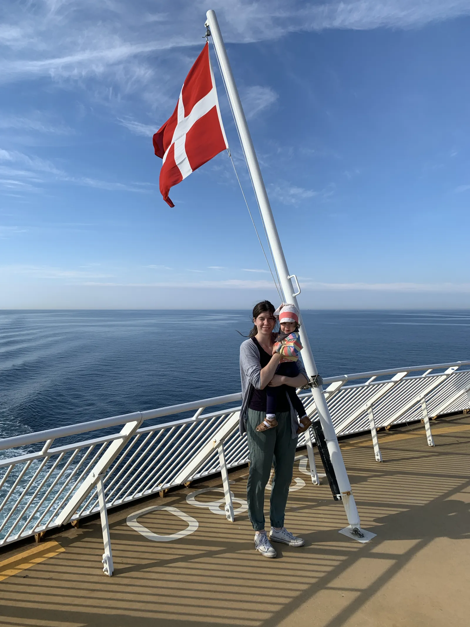 Jule mit Baby unter der dänischen Flagge auf dem Vorderdeck.